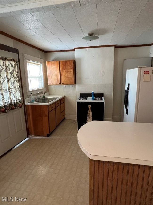 Kitchen with sink, refrigerator, and crown molding | Image 4
