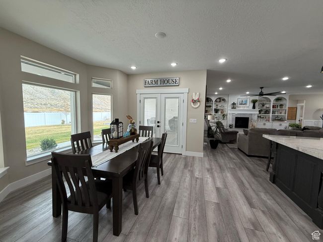 Dining room with a textured ceiling, baseboards, recessed lighting, a ceiling fan, and light wood-style floors | Image 27