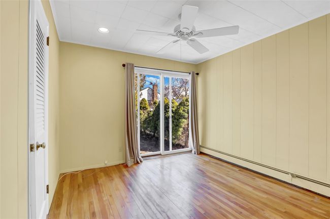 Unfurnished room featuring a baseboard heating unit, wood-type flooring, baseboards, and ceiling fan | Image 13