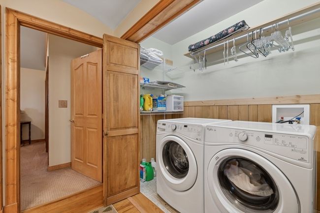 Laundry room featuring washer and clothes dryer and laundry area on main level. | Image 51