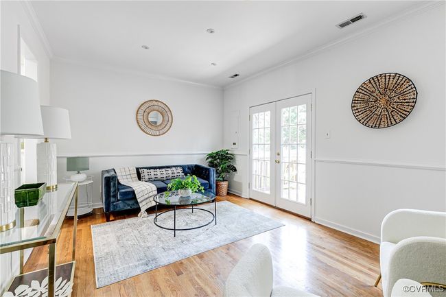 Living Room with hardwood floors, wood-burning fireplace, built-ins and French doors to back deck and fenced yard. | Image 15