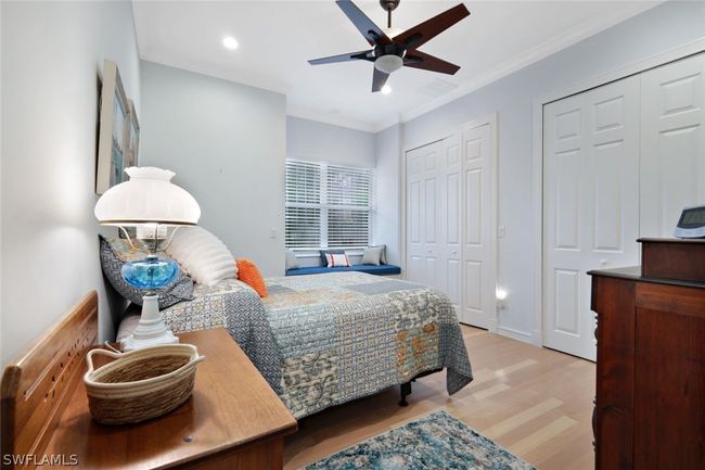 Bedroom with two closets, ceiling fan, hardwood / wood-style floors, and crown molding | Image 25
