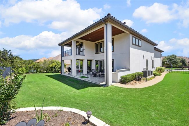 Back of property with stucco siding, a patio, a balcony, central AC, and a yard | Image 35