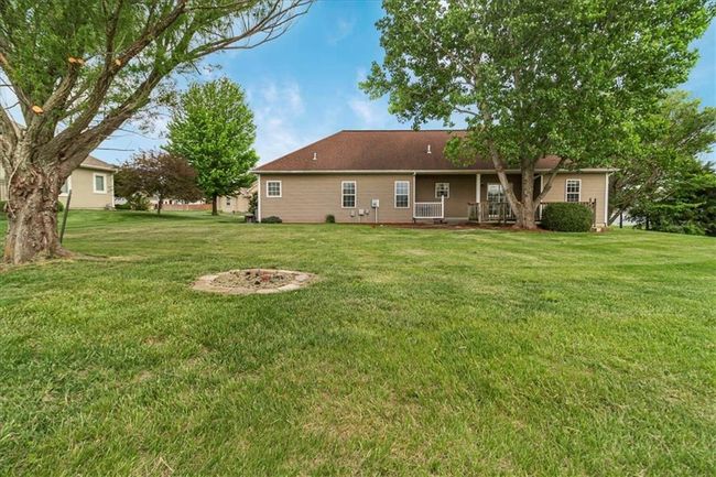 Rear view of house with a lawn and a porch | Image 5