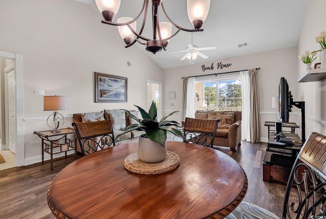 Dining room featuring wood finished floors, ceiling fan, lofted ceiling, and visible vents | Image 9