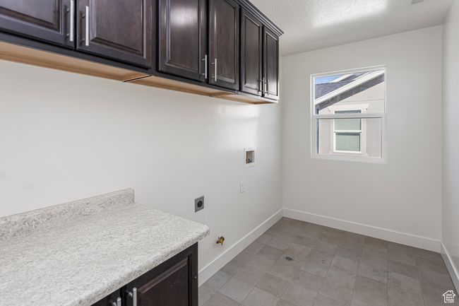 Clothes washing area with hookup for an electric dryer, washer hookup, cabinet space, and baseboards | Image 38