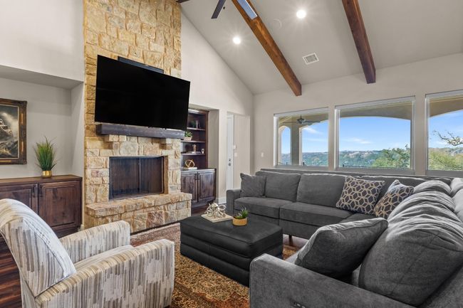 Living area featuring a fireplace, wood finished floors, visible vents, and beamed ceiling | Image 6