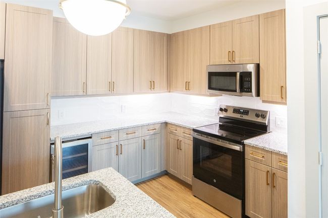 Kitchen with stainless steel appliances, light wood finished floors, a sink, and light brown​​‌​​​​‌​​‌‌​‌‌​​​‌‌​​‌‌​‌​​​​​‌ cabinetry | Image 10