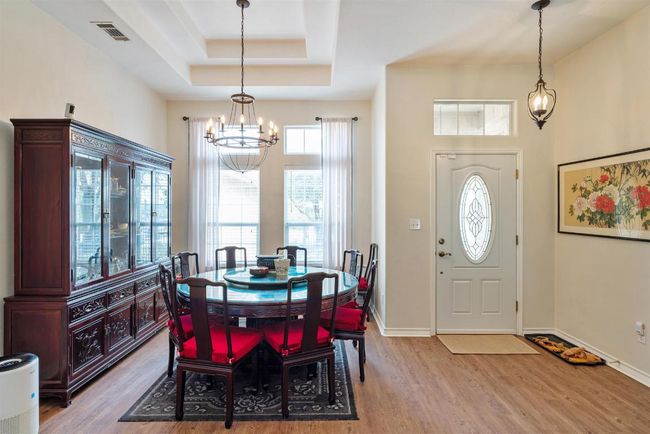 Foyer entrance with an inviting chandelier, wood finished floors, visible vents, and baseboards | Image 4