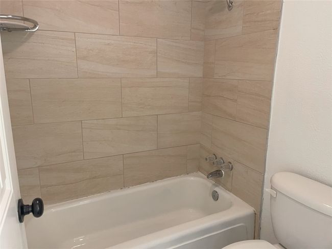 Bathroom featuring toilet and bathtub / shower combination | Image 5