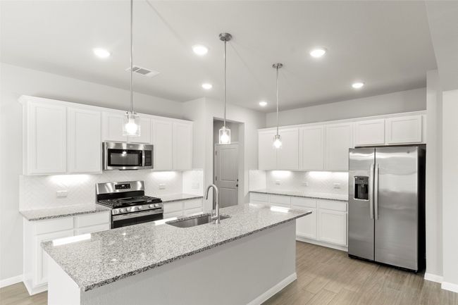 Kitchen with stainless steel appliances, a sink, decorative backsplash, light wood-type flooring, and recessed lighting | Image 18