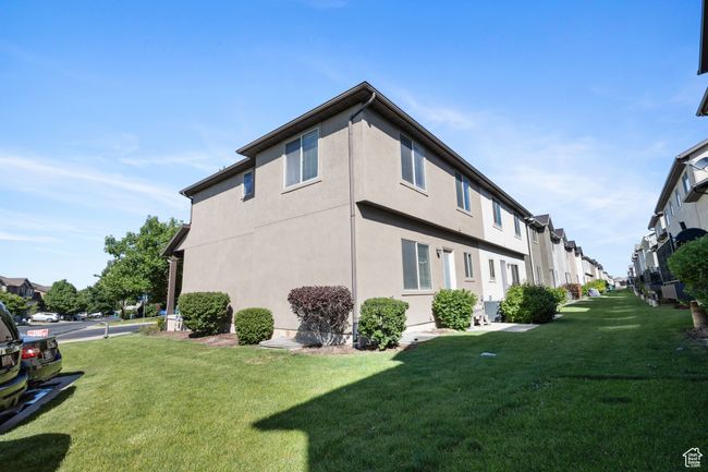 View of property exterior with a yard, stucco siding, and a residential view | Image 32
