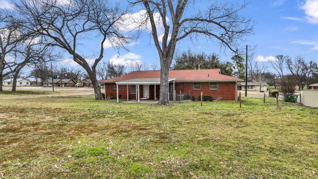 Rear view of property featuring mature trees and expansive yard | Image 25
