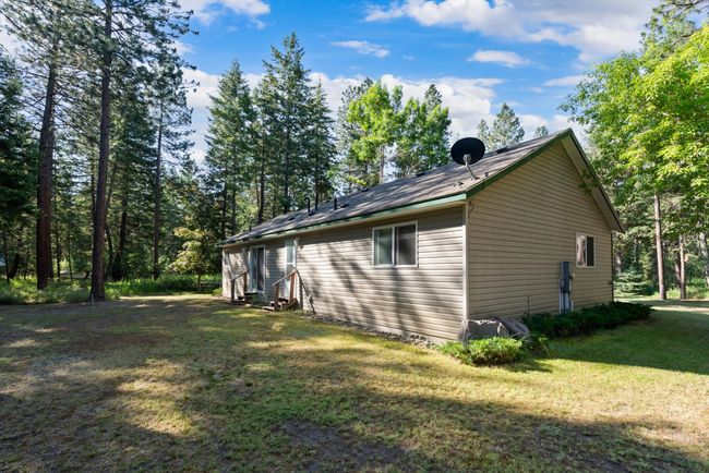 View of property exterior with entry steps and a lawn | Image 7