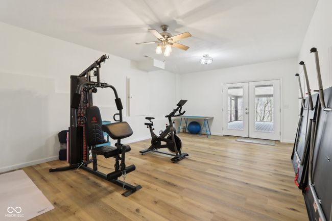 exercise room featuring french doors, a ceiling fan, baseboards, and light wood-type flooring | Image 47