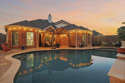 Pool at dusk featuring a patio area | Image 1