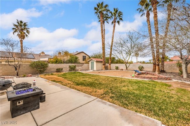 View of yard featuring a storage unit, a patio, a fenced backyard, and an outdoor structure | Image 5