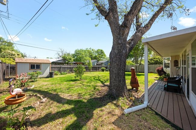 View of yard with a fenced backyard, a wooden deck, an outdoor structure, and a storage unit | Image 23