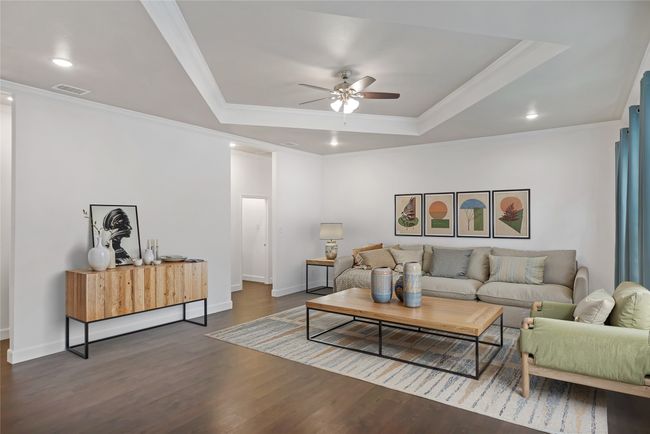 Living room featuring ornamental molding, ceiling fan, a tray ceiling, wood finished floors, and recessed lighting | Image 9