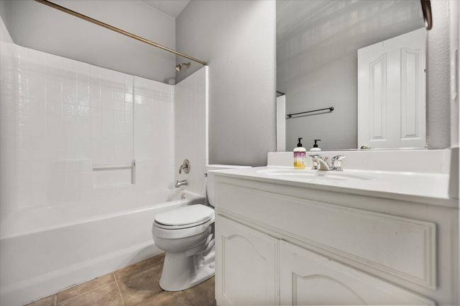 Bathroom featuring vanity and washtub / shower combination | Image 18