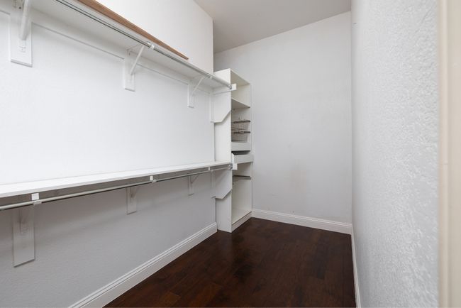Spacious closet with dark wood-type flooring | Image 22