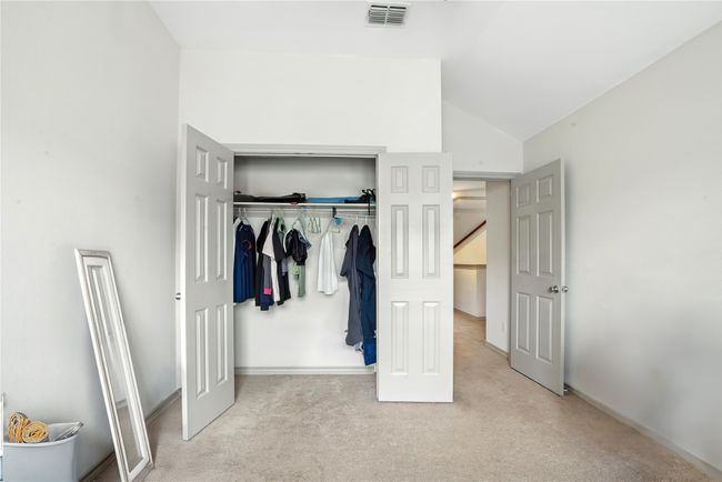 Unfurnished bedroom with carpet floors, a closet, and lofted ceiling | Image 27