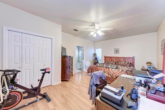 Bedroom featuring light wood-type flooring, a closet, ceiling fan, ensuite bath, and baseboards | Image 23