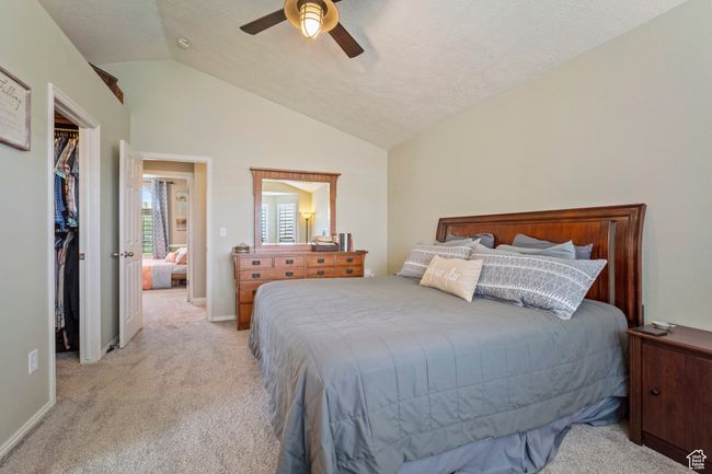 Bedroom with lofted ceiling, ceiling fan, a closet, light carpet, and a spacious closet | Image 11