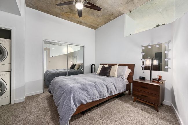 Bedroom featuring stacked washing machine and dryer, carpet, baseboards, and a ceiling fan | Image 12