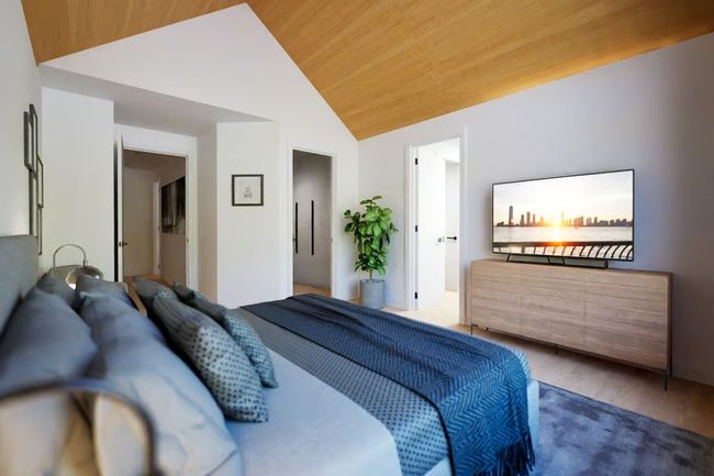 Bedroom with vaulted ceiling and wood floors to add warmth. | Image 16