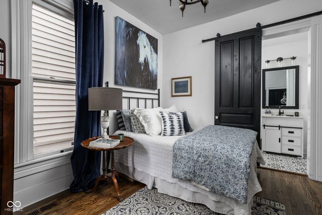 Bedroom with Hardwood floors, barn door and attached full bathroom | Image 10