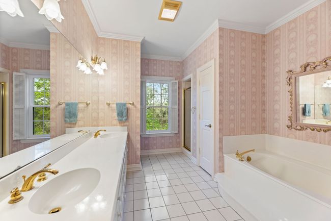 Full bath featuring plenty of natural light, a garden tub, double vanity, and crown molding | Image 25