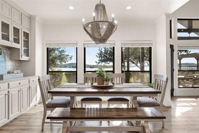 Dining space featuring a chandelier, light wood-type flooring, recessed lighting, ornamental molding, and a water view | Image 16