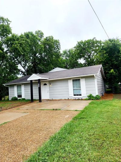 Ranch-style home featuring a garage and a front lawn | Image 1