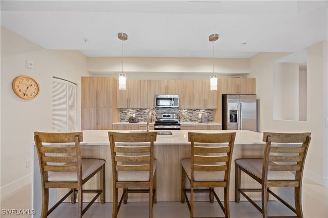 Kitchen with tasteful backsplash, light countertops, a sink, stainless steel appliances, and light brown cabinets | Image 16