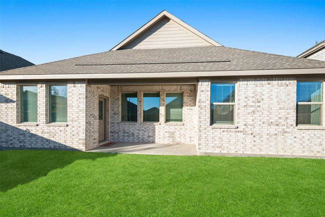 Rear view of property with a yard, a patio, brick siding, and a shingled roof | Image 23