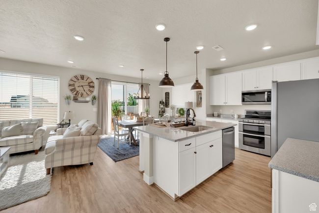 Kitchen with appliances with stainless steel finishes, a sink, light wood-style floors, recessed lighting, and open floor plan | Image 14