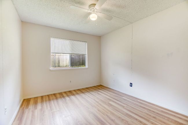 Unfurnished room with light wood-style flooring, a ceiling fan, a textured ceiling, and baseboards | Image 13