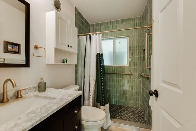 Bathroom with toilet, vanity, and a stall shower | Image 13