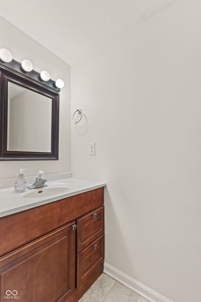 bathroom featuring vanity, tile patterned floors, baseboards, and a textured ceiling | Image 8
