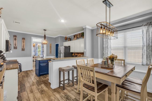 Dining space with ornamental molding, hardwood / wood-style floors, and an inviting chandelier | Image 14