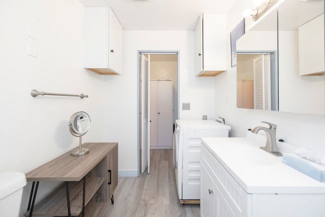 Laundry room with washer and dryer and light wood-style floors | Image 7