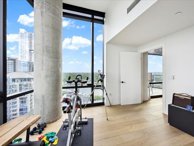 Exercise area featuring hardwood / wood-style floors, a wall of windows, a city view, and a water view | Image 5