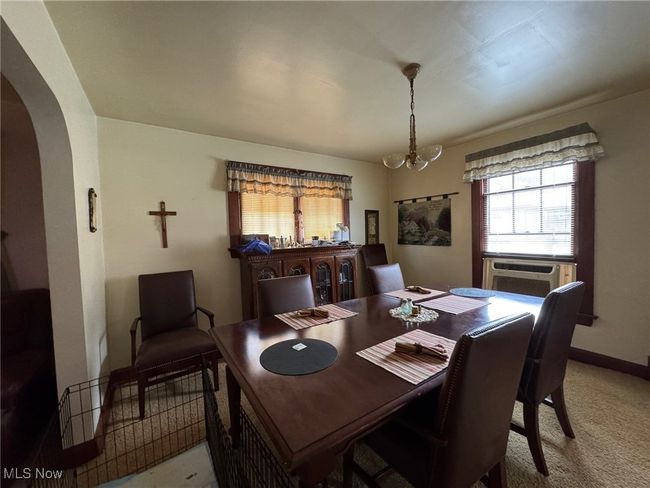 Dining area with arched walkways, a chandelier, cooling unit, and a healthy amount of sunlight | Image 6
