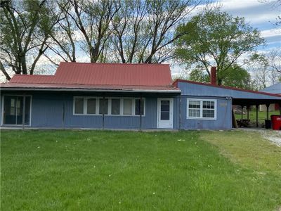 Rear view of house featuring a carport and a lawn | Image 1