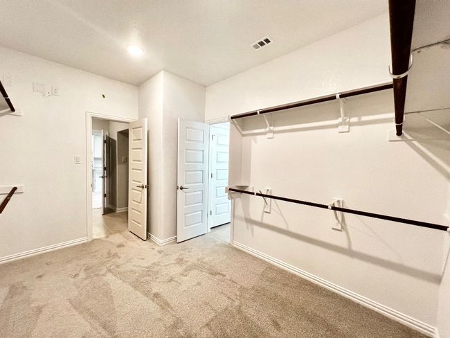 Spacious closet with light carpet | Image 16
