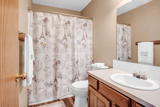 Full bathroom featuring toilet, vanity, and curtained shower | Image 15