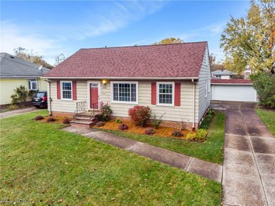 Bungalow-style house with an outbuilding, a garage, and a front lawn | Image 1