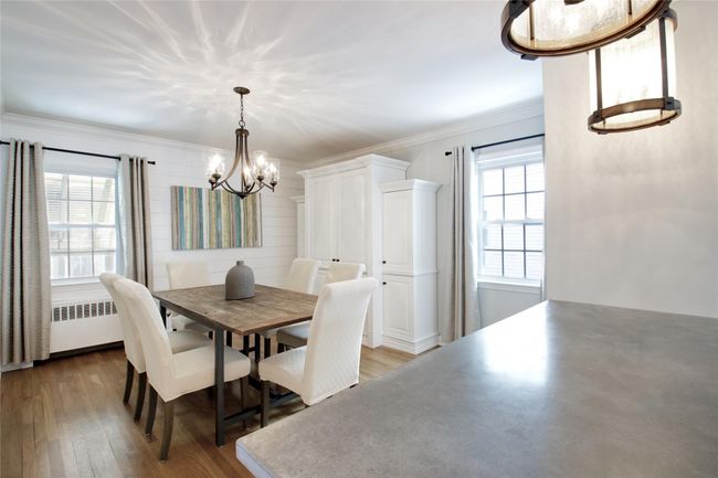 Dining room with a chandelier, wood finished floors, crown molding, and radiator | Image 4