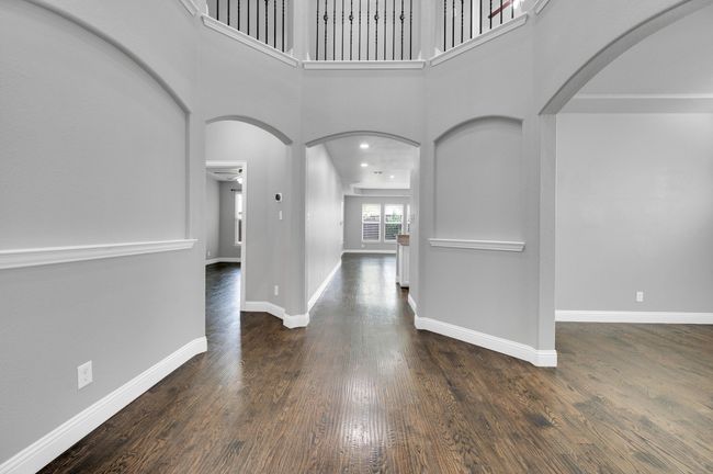 Leading into family living area. Beautiful hardwood floors and decorative crown molding. | Image 8